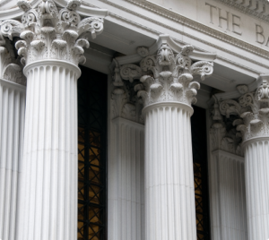 Close-up of ornate Corinthian columns on a historic bank building facade with detailed stone carvings.