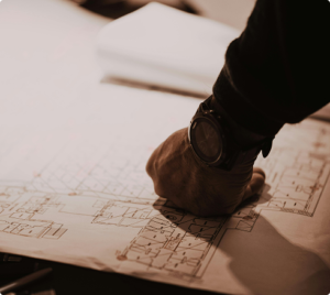 Close-up of a professional reviewing commercial building blueprints, highlighting architectural planning and renovation work.