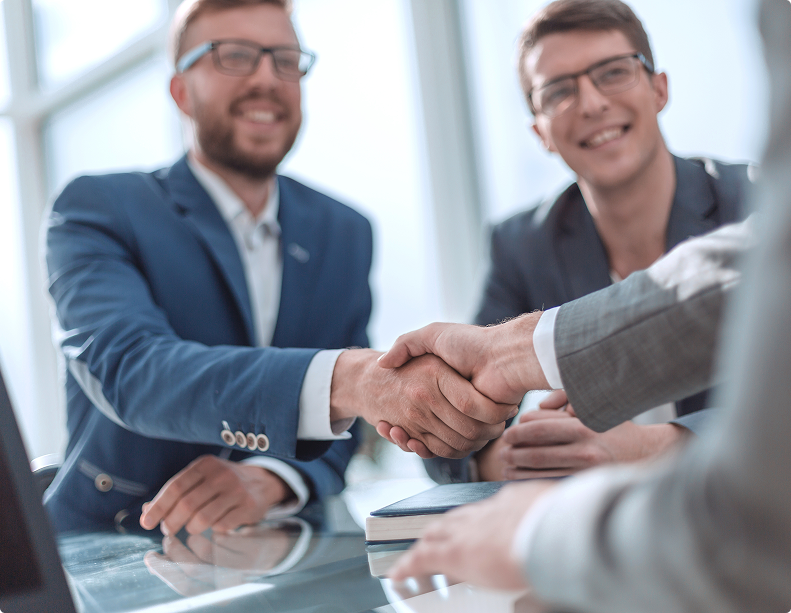 Business professionals shaking hands during a successful meeting or agreement in a modern office setting.