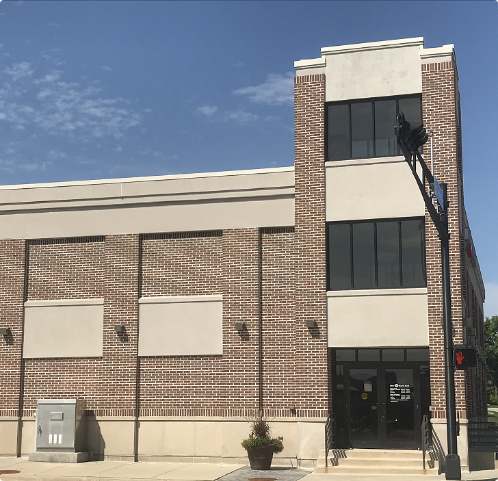 Modern brick bank building with street-facing entrance, representing a potential sale-leaseback property managed by Brookline Asset Management.